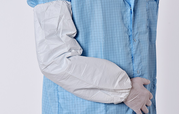 DYNOtex microGuard sleevePerson trägt blauen Kittel mit DYNOtex microGuard sleeve – atmungsaktiver, mikroporöser Ärmelschoner mit elastischen Gummizügen.