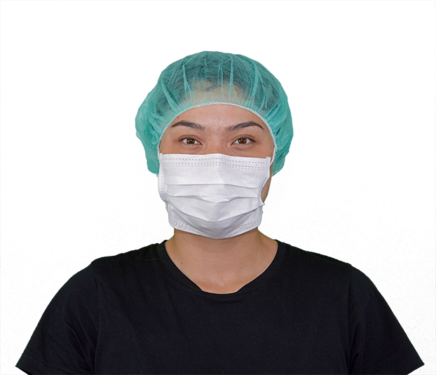 Masque, 18 cm, avec bandeau elastiquePerson trägt einen weissen Mundschutz mit Ohrschleifen und einer grünen Haube.