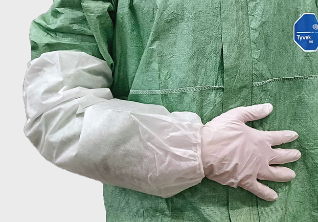DYNOtex spunGuard sleeveGrüner Overall mit einem weissen Ärmelschoner. DYNOtex spunGuard Ärmelschoner – Atmungsaktiver und staubdichter Armschutz aus SMS mit elastischem Gummizug