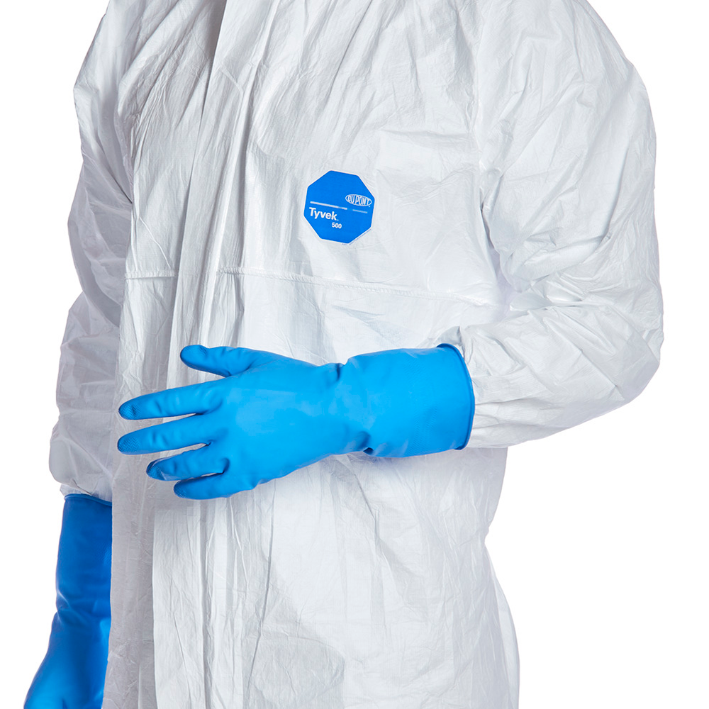 Tyvek® 500 Xpert Anzug mit KapuzePerson trägt einen weissen Reinraum-Overall mit hellblauen Handschuhen und einem hellblauen Logo auf der linken Brust.
